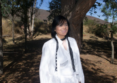 Anita Jansson con árboles un cerro de fondo